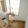 View of curved staircase from top with glass panel to upper lounge